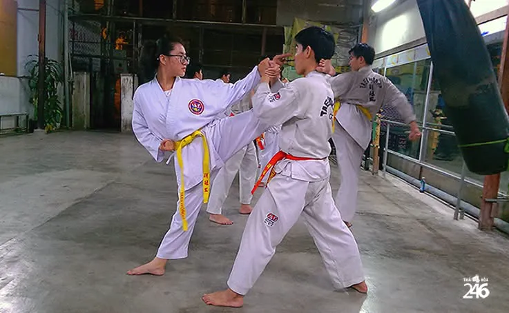 Võ sinh đai vàng và đai đỏ tập đối luyện: một người đá, một người đỡ.
